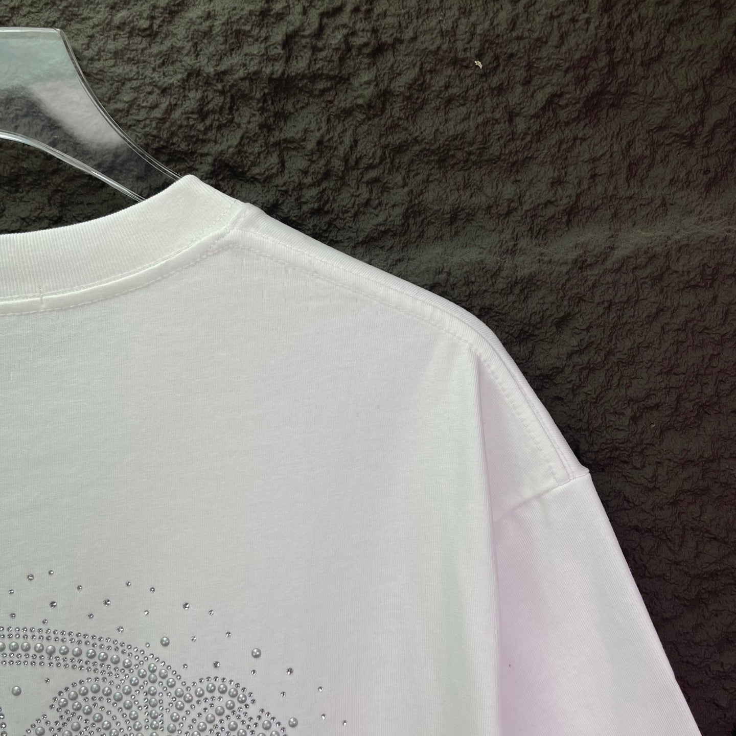 White short-sleeve T-shirt with rhinestone logo along the lower back