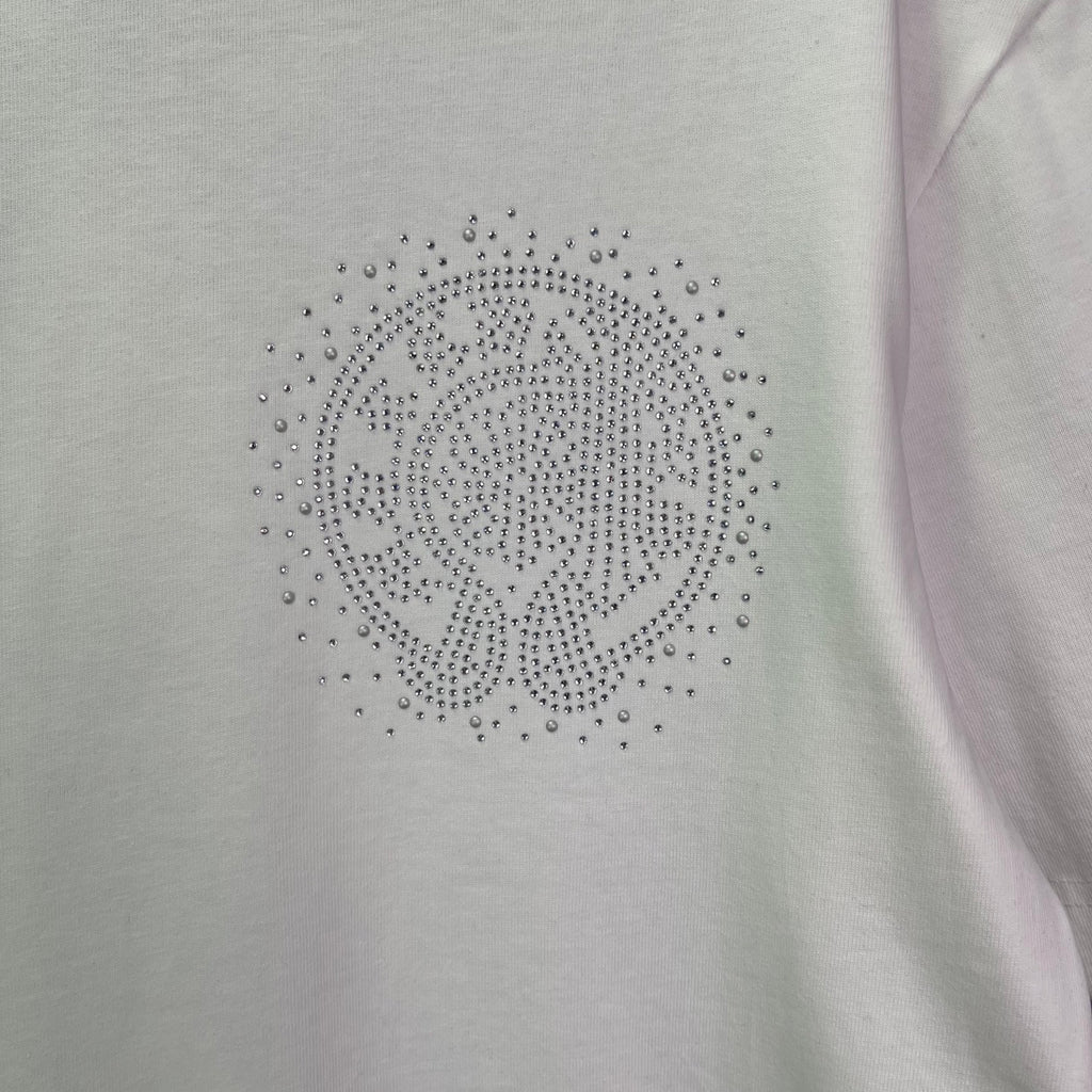 Close-up of rhinestone emblem on a light T-shirt