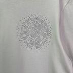 Close-up of rhinestone emblem on a light T-shirt