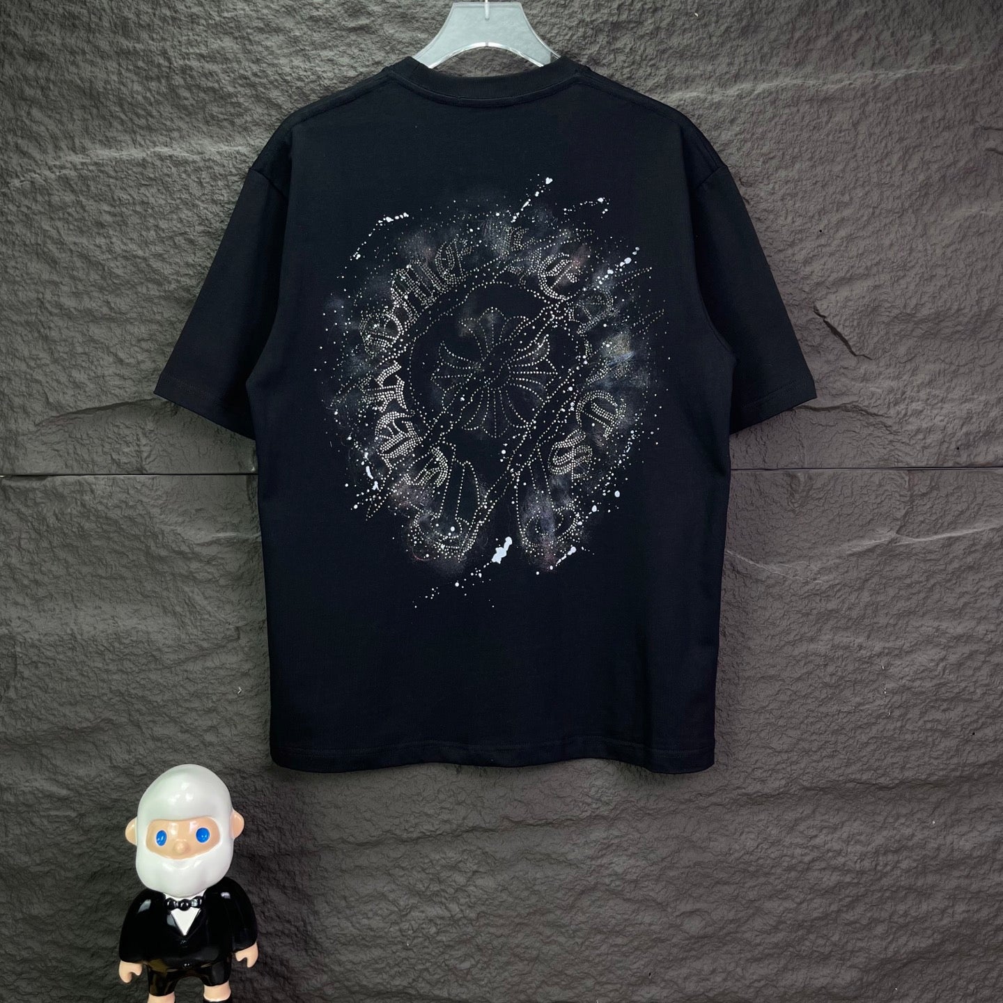 Black short-sleeve T-shirt with large rhinestone-style emblem graphic on back.