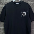 Black short-sleeve T-shirt with rhinestone-style heart-like emblem on left chest.