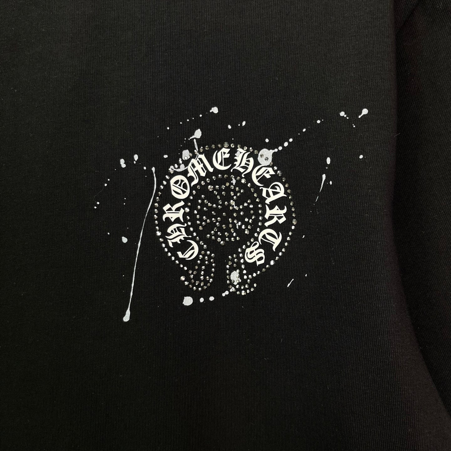 Black short-sleeve T-shirt with large rhinestone-style crest emblem print at center.