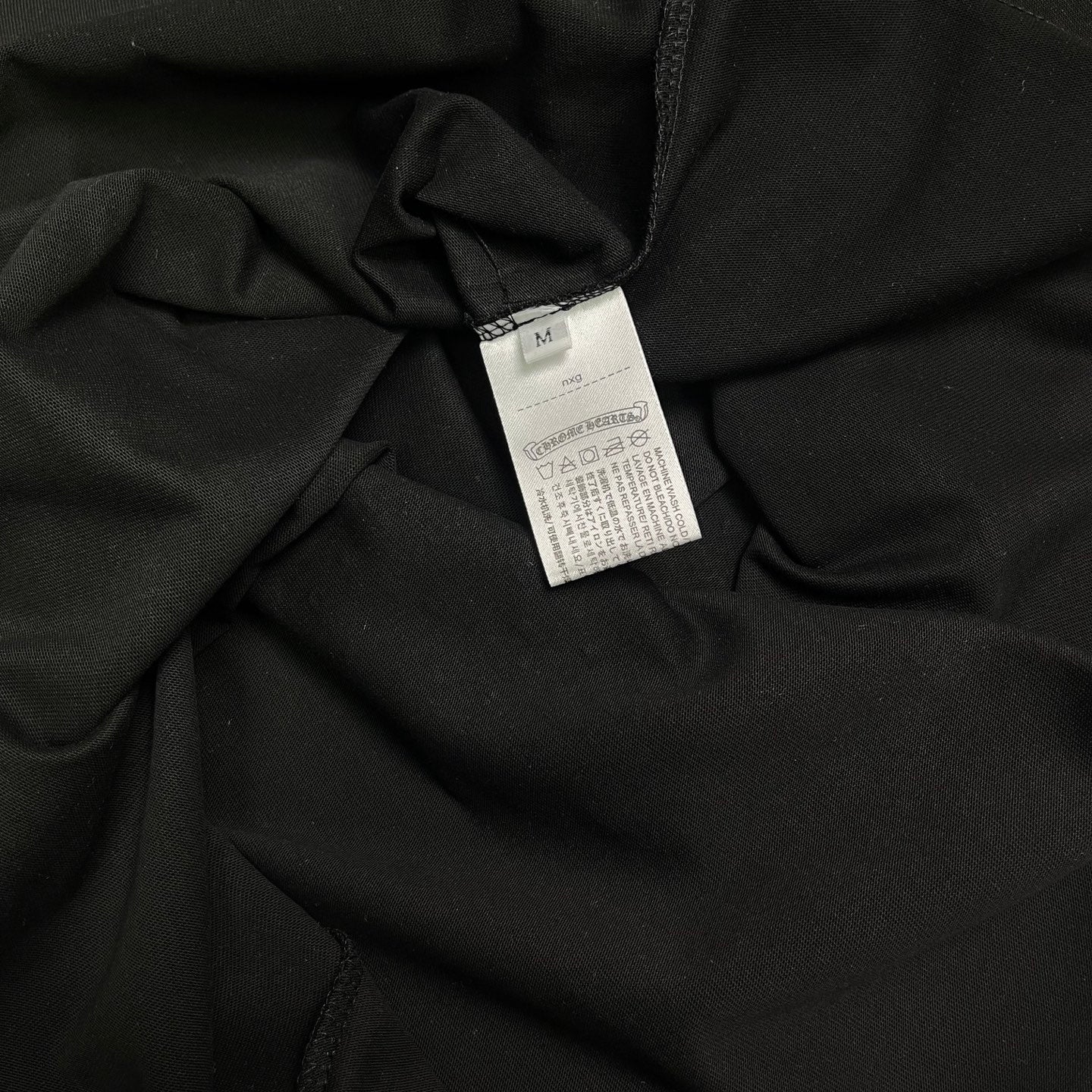 Black T-shirt fabric close-up with white size label