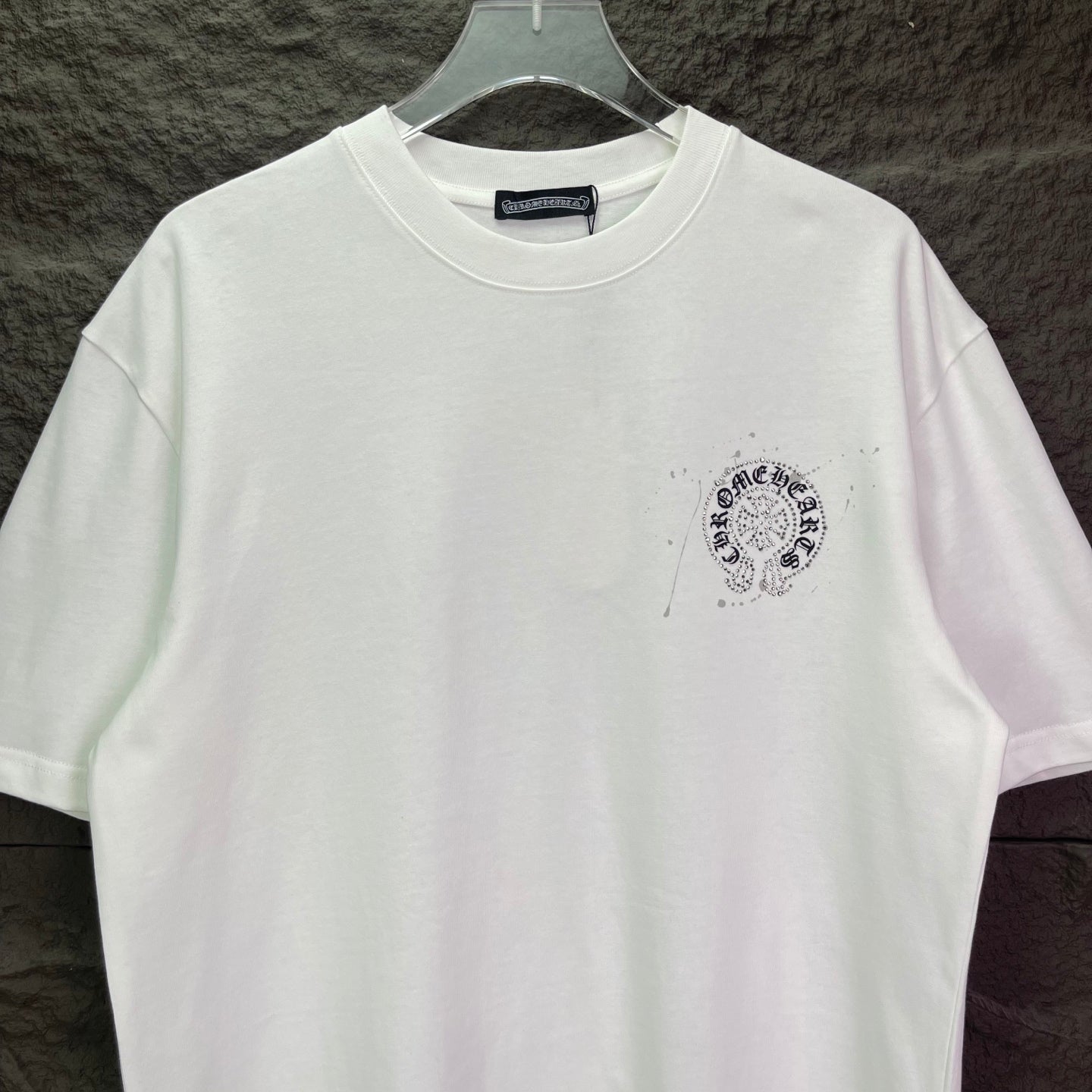 White crew-neck T-shirt with small round rhinestone chest logo