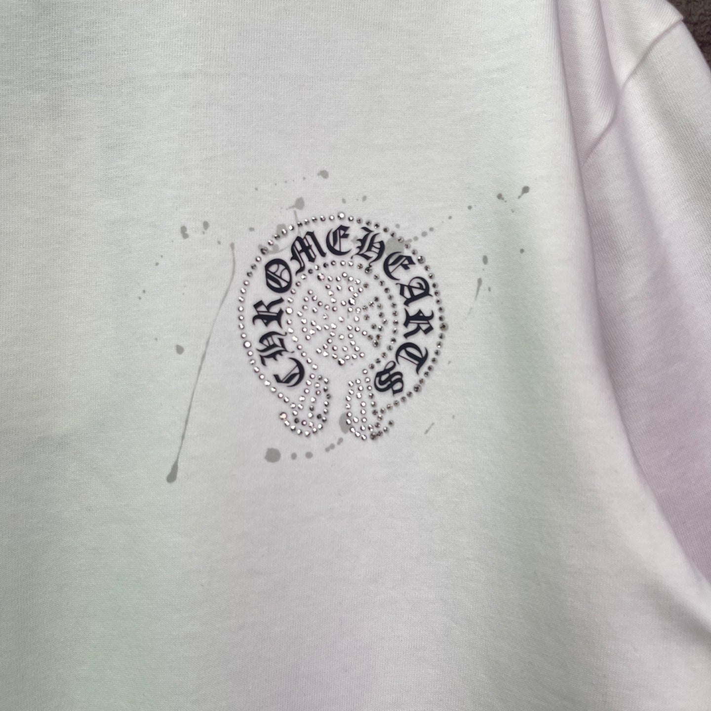 White T-shirt with round rhinestone crest graphic at chest