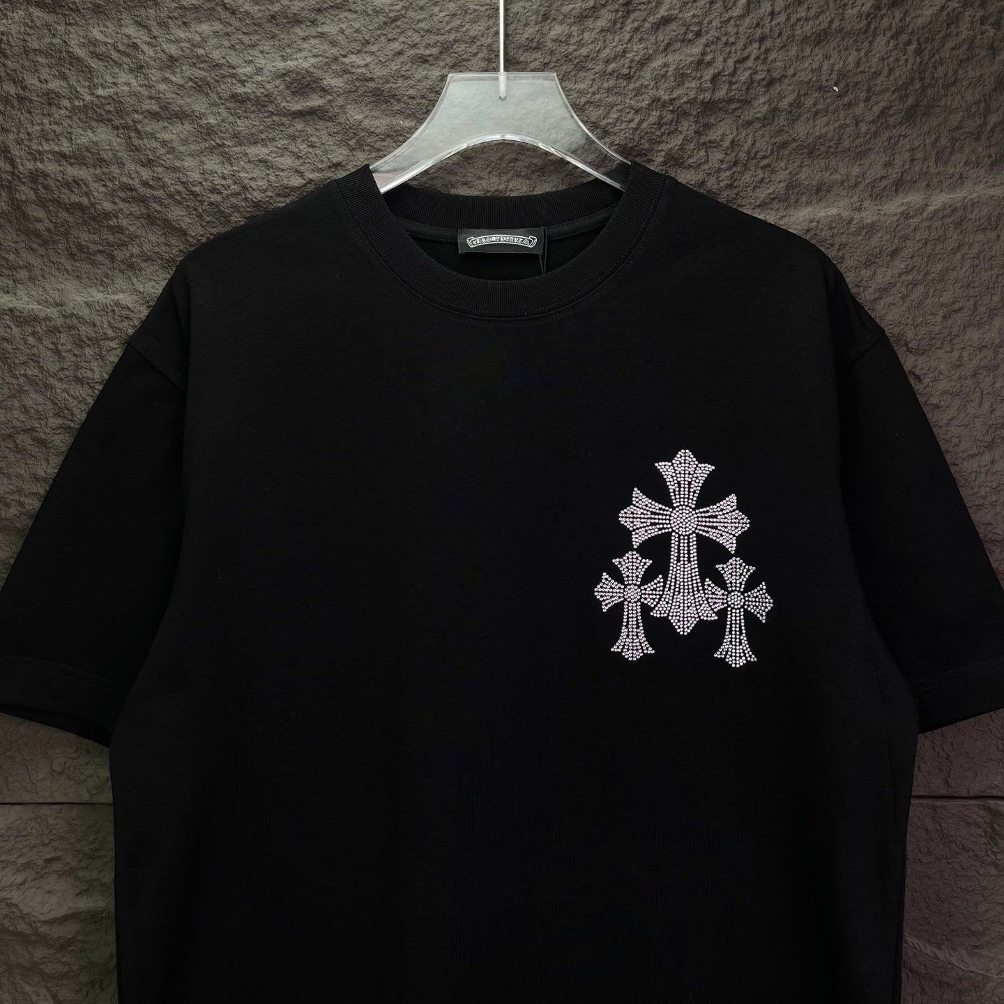Black short-sleeve T-shirt with small rhinestone cross on left chest