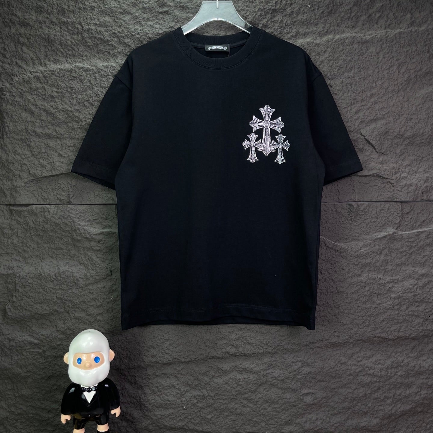 Black short-sleeve T-shirt with small rhinestone cross on left chest