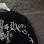 Black T-shirt sleeve detail with rhinestone cross and patterned lettering