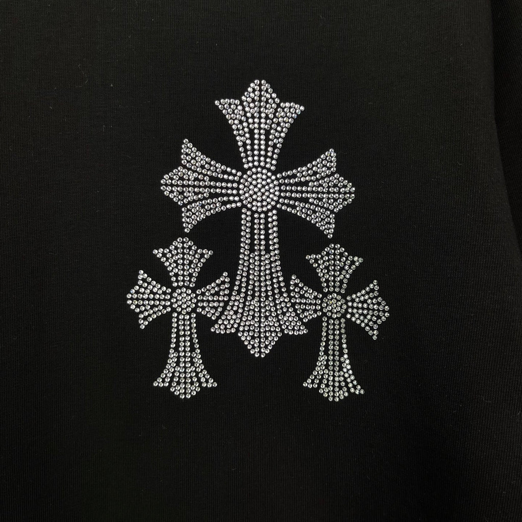 Black T-shirt close-up of large rhinestone cross embellishment