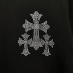 Black T-shirt close-up of large rhinestone cross embellishment