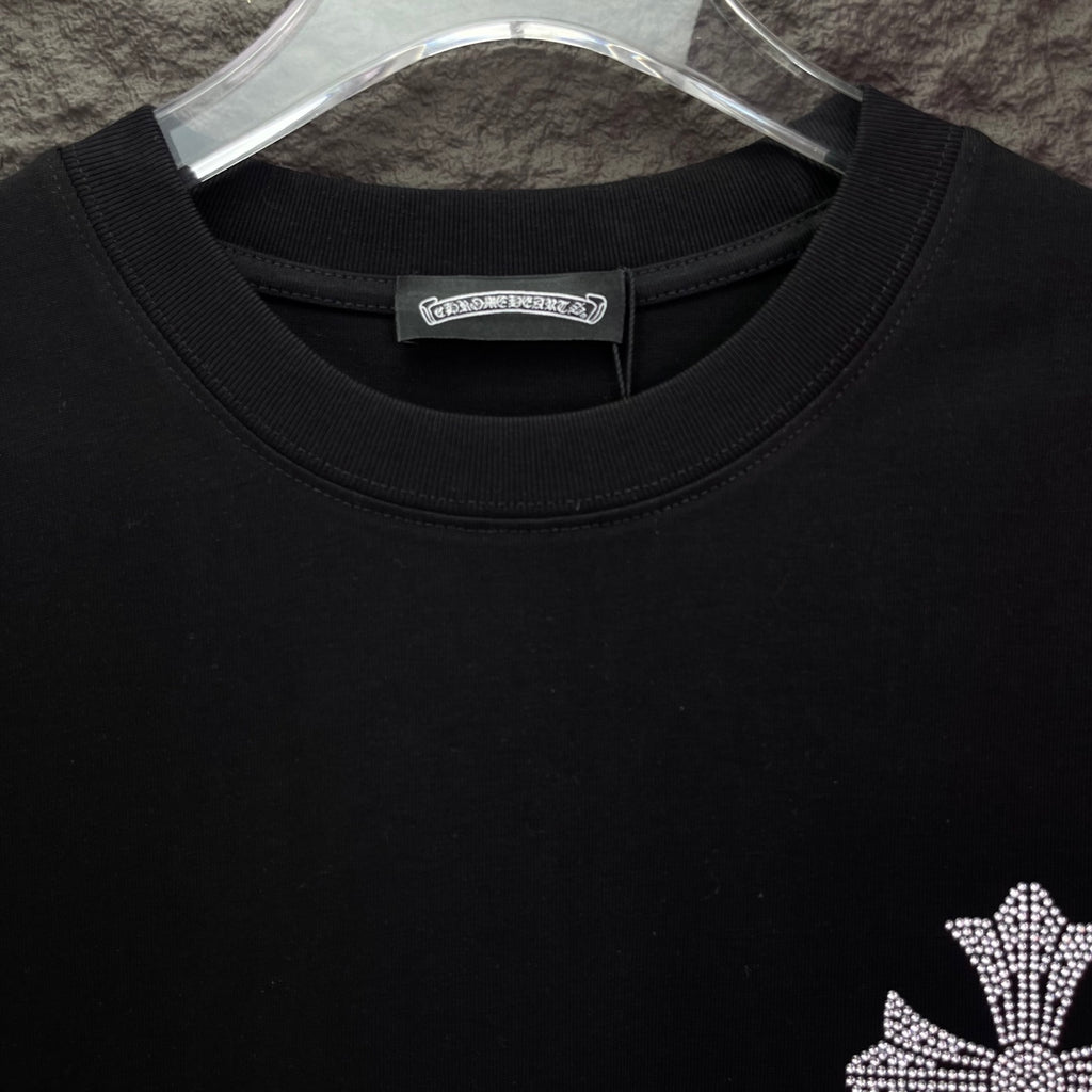Black T-shirt close-up of crew neck and small rhinestone cross detail
