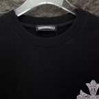 Black T-shirt close-up of crew neck and small rhinestone cross detail