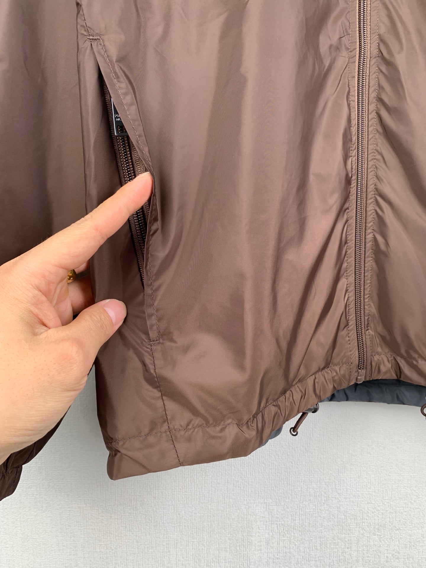 Brown jacket close-up with side zipper and inner seam