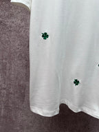 White T-shirt bottom with green clover embroidery at left side