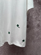 White T-shirt hem with green clover embroidery and small Dior logo detail