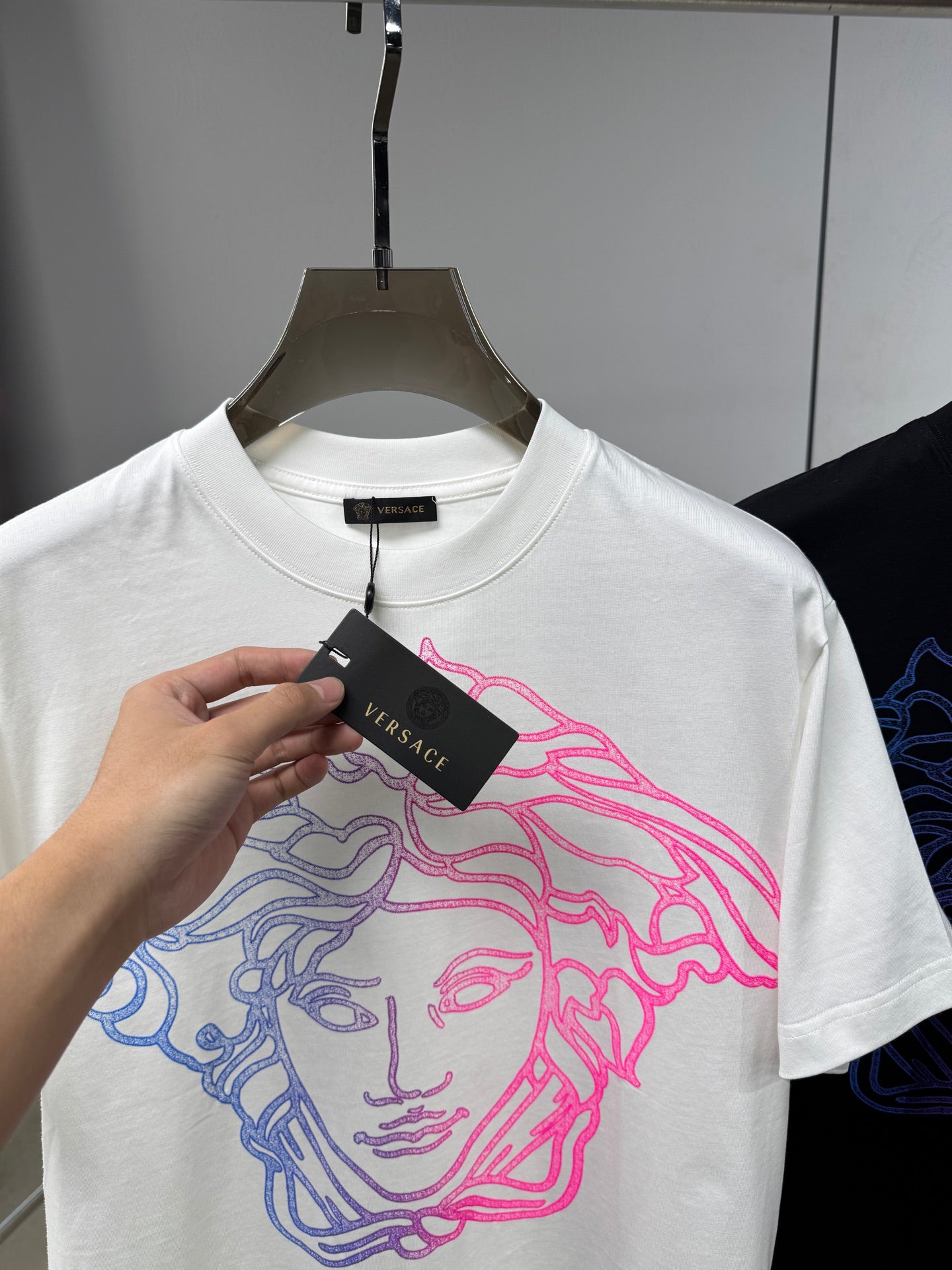 White Versace crewneck T-shirt with neon blue and pink Medusa graphic and tag