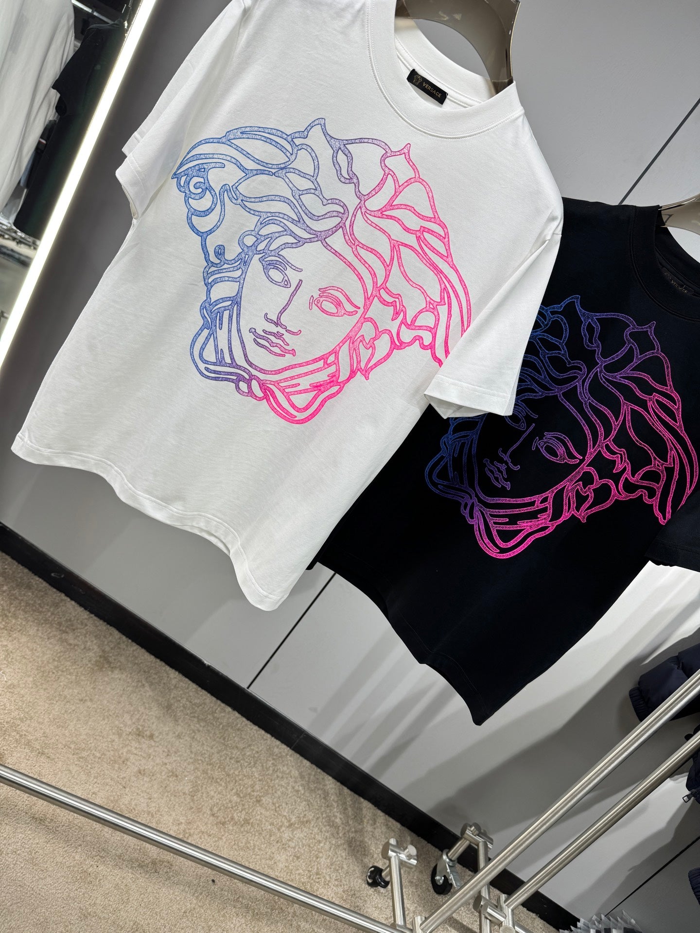 White and black Versace crewneck T-shirts with neon Medusa line-art chest graphics