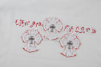 White fabric appliqué patch trio with red edges and a central cross motif