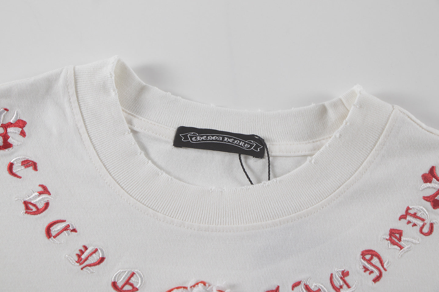 White short-sleeve T-shirt neckline with black brand label and red embroidered detailing