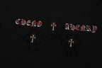 Black T-shirt front detail with red lettering and three circular cross patches