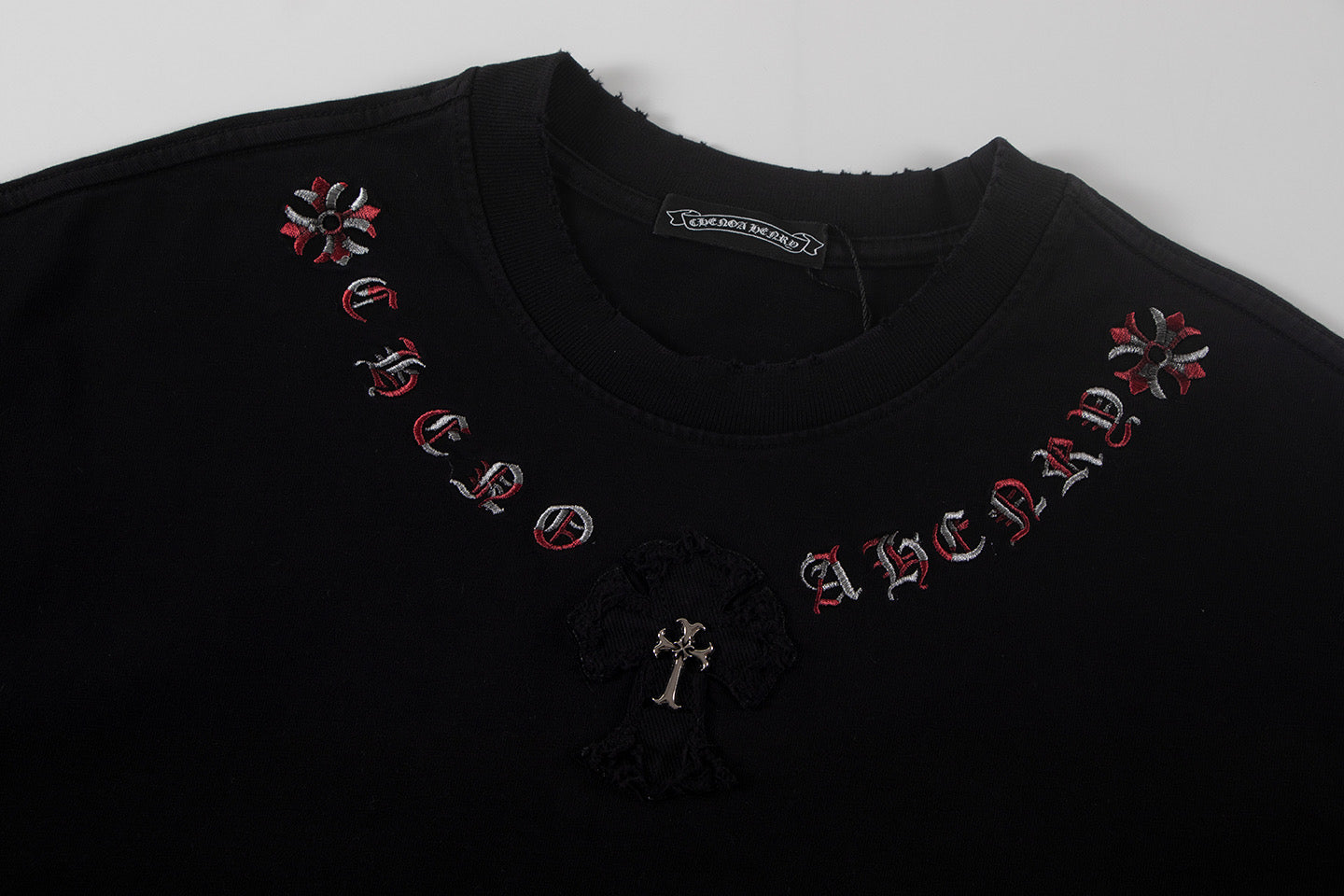 Black short-sleeve T-shirt with red cross motifs and central dark patch