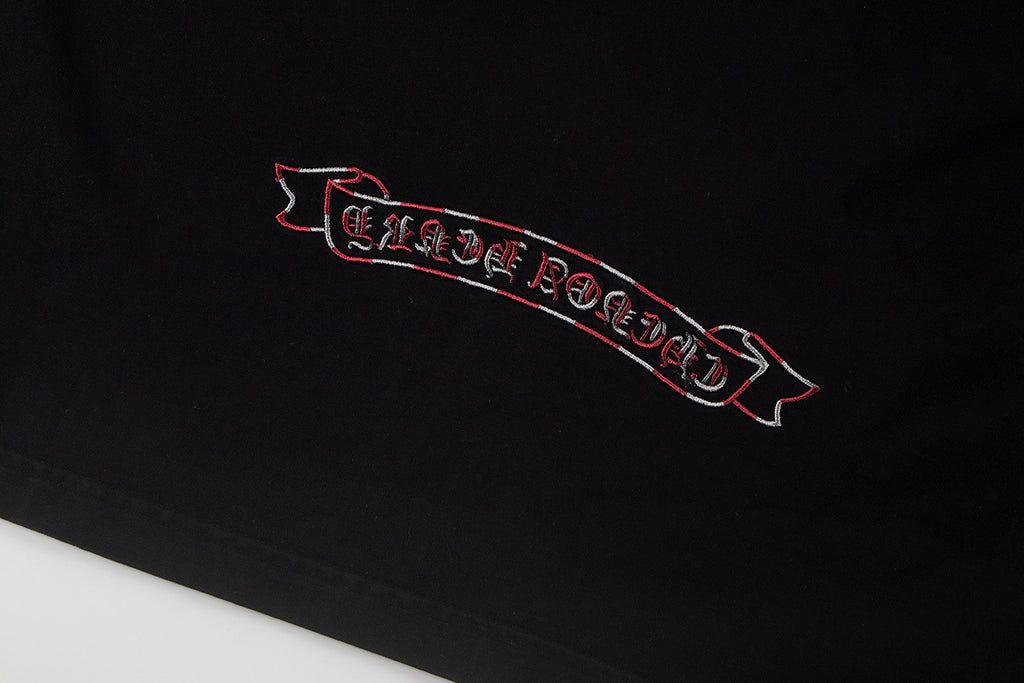 Black T-shirt front detail with red outlined banner graphic
