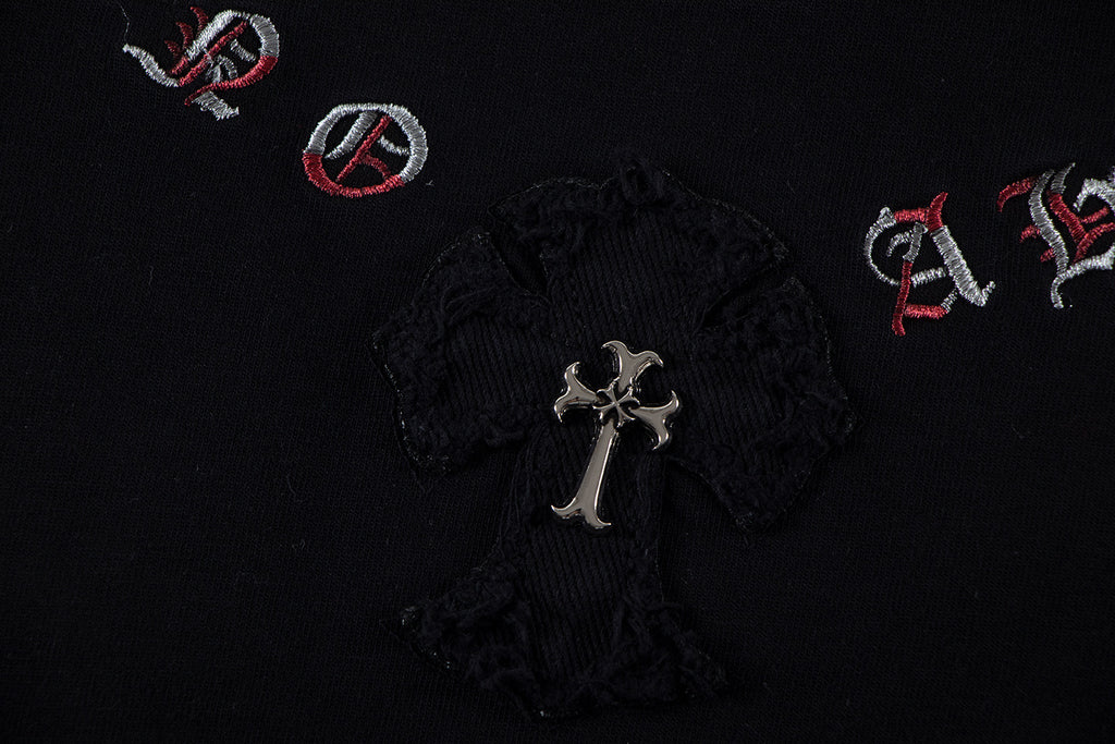 Black T-shirt fabric detail with central cross emblem and small red icons