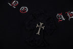 Black T-shirt fabric detail with central cross emblem and small red icons