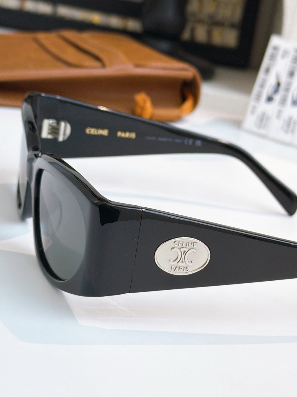 Black sunglasses side view with dark lens and oval logo on temple.