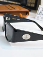 Black sunglasses side view with dark lens and oval logo on temple.