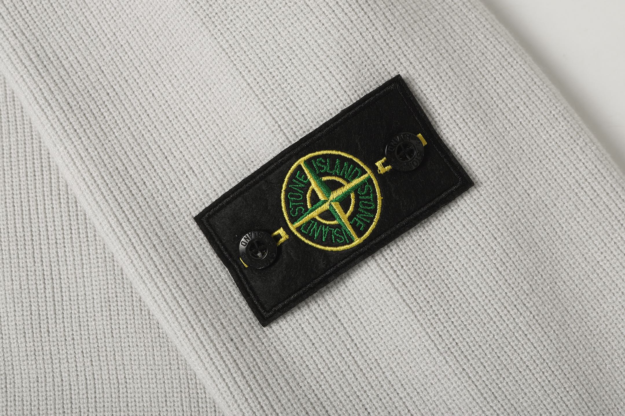Light gray knit jacket sleeve patch with Stone Island logo