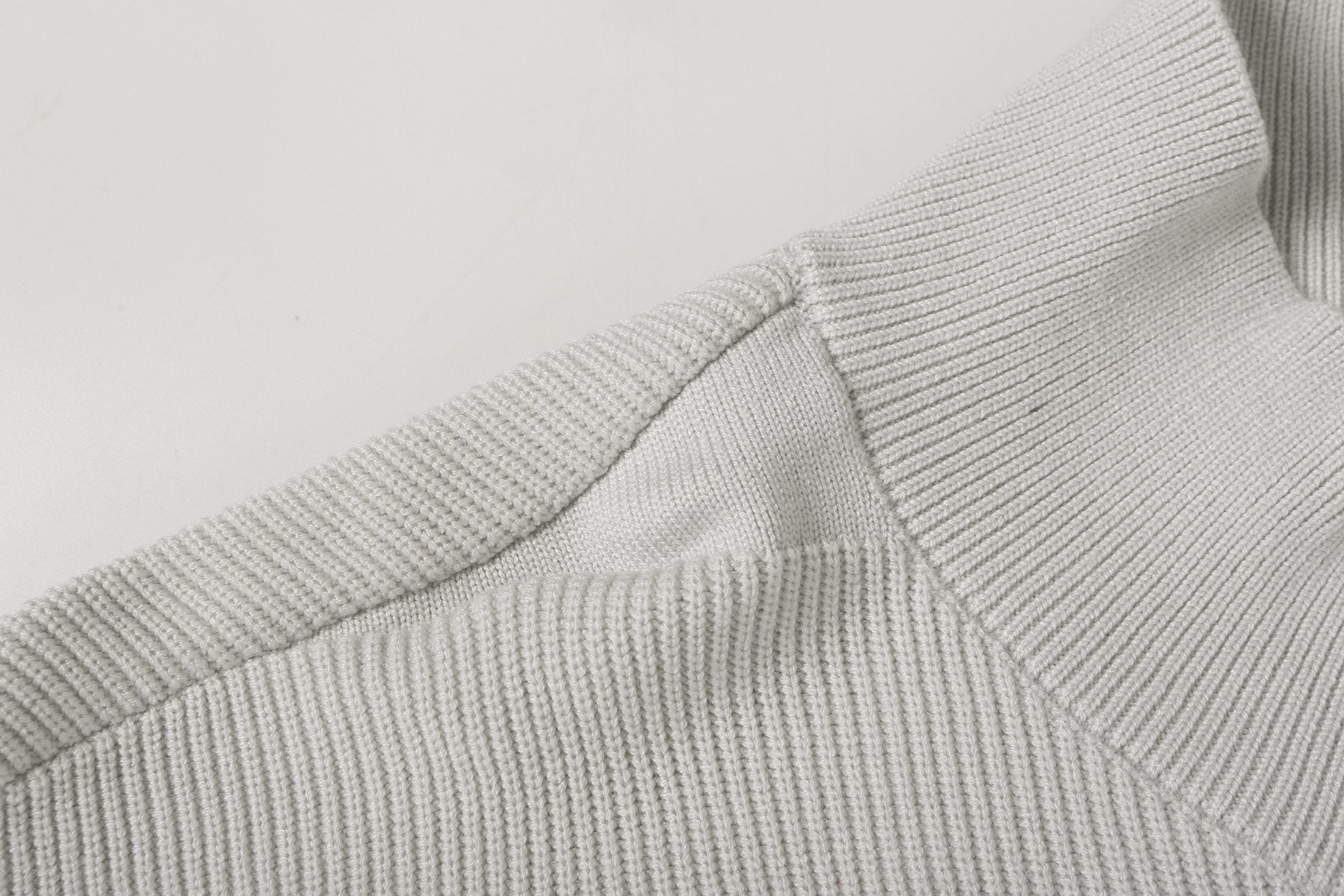 Light gray ribbed knit jacket shoulder and collar seam detail