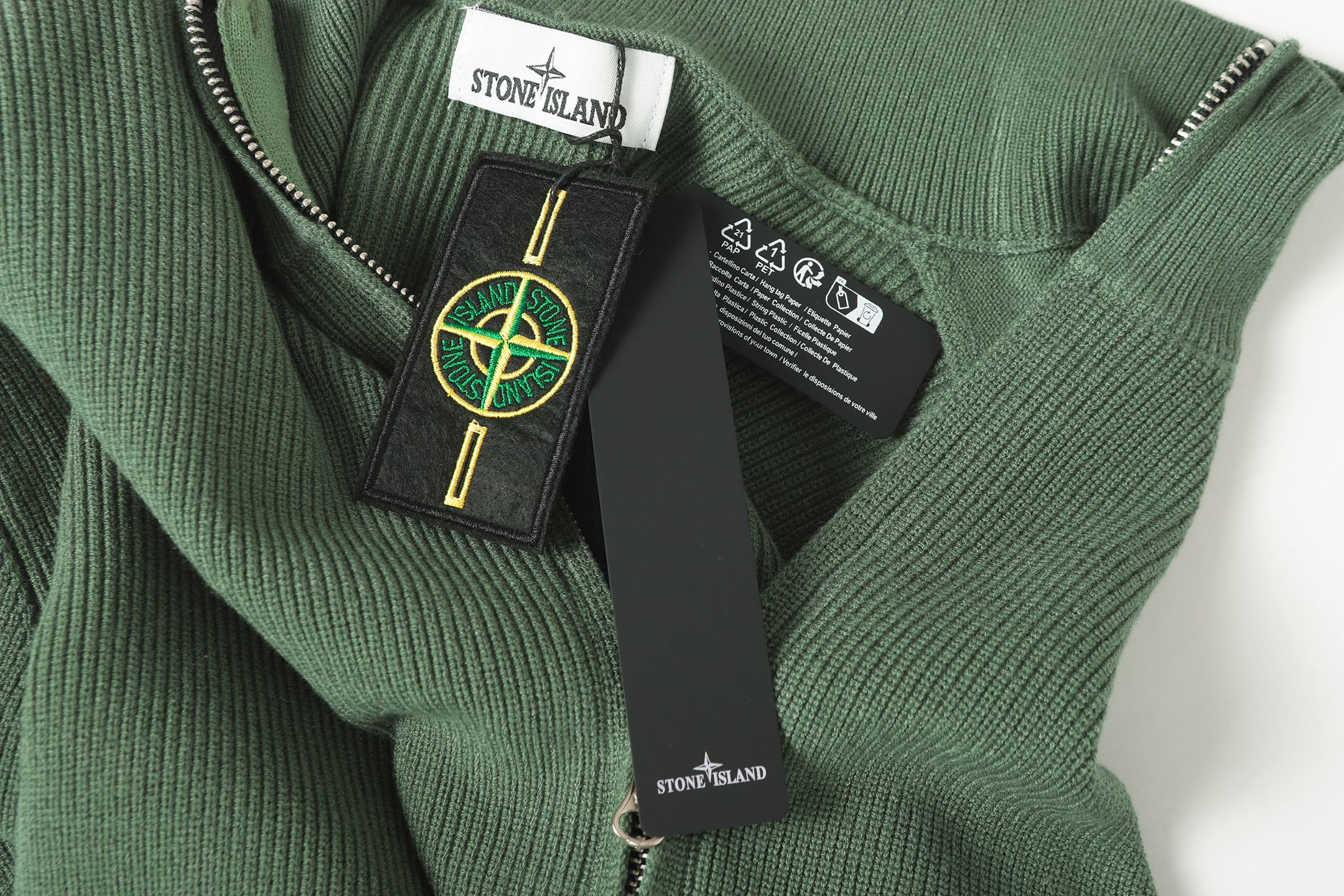 Stone Island zip jacket neckline label and care tag on dark green knit