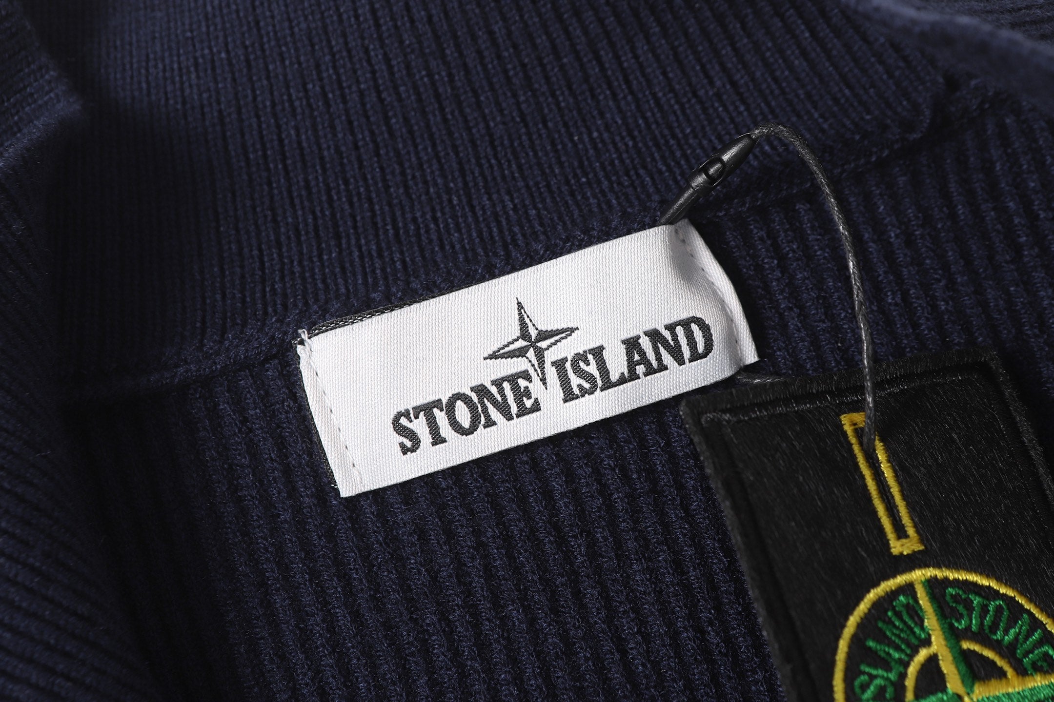 Stone Island brand label and logo patch on dark navy knit zip jacket