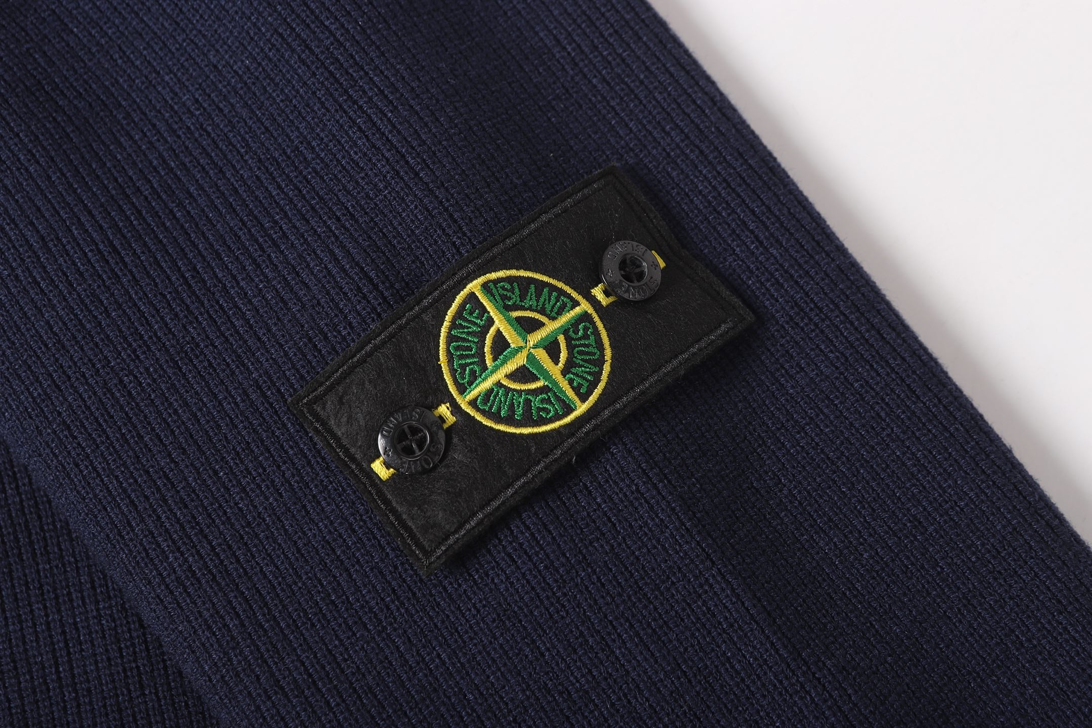 Stone Island logo patch on dark navy knit jacket sleeve