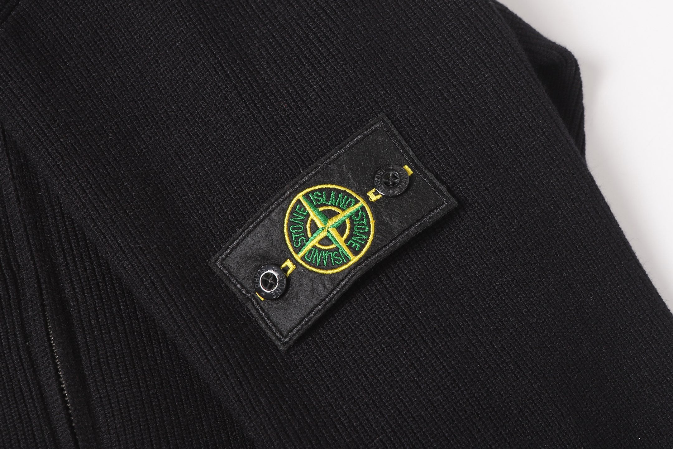 Stone Island black jacket chest emblem patch on dark fabric