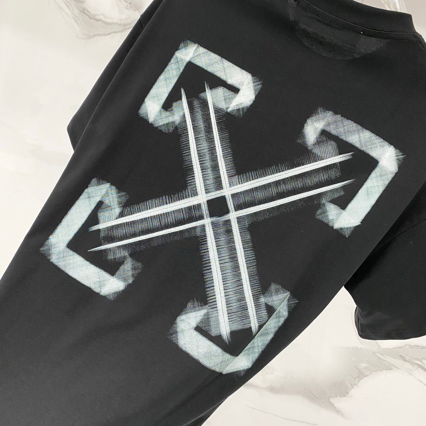 Black T-shirt with large white-blue arrow and cross graphic