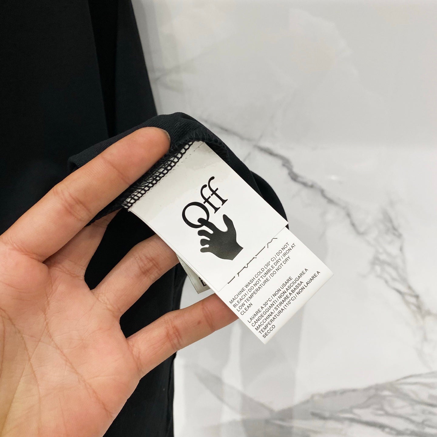 Black T-shirt care label with Off logo on the inside neck