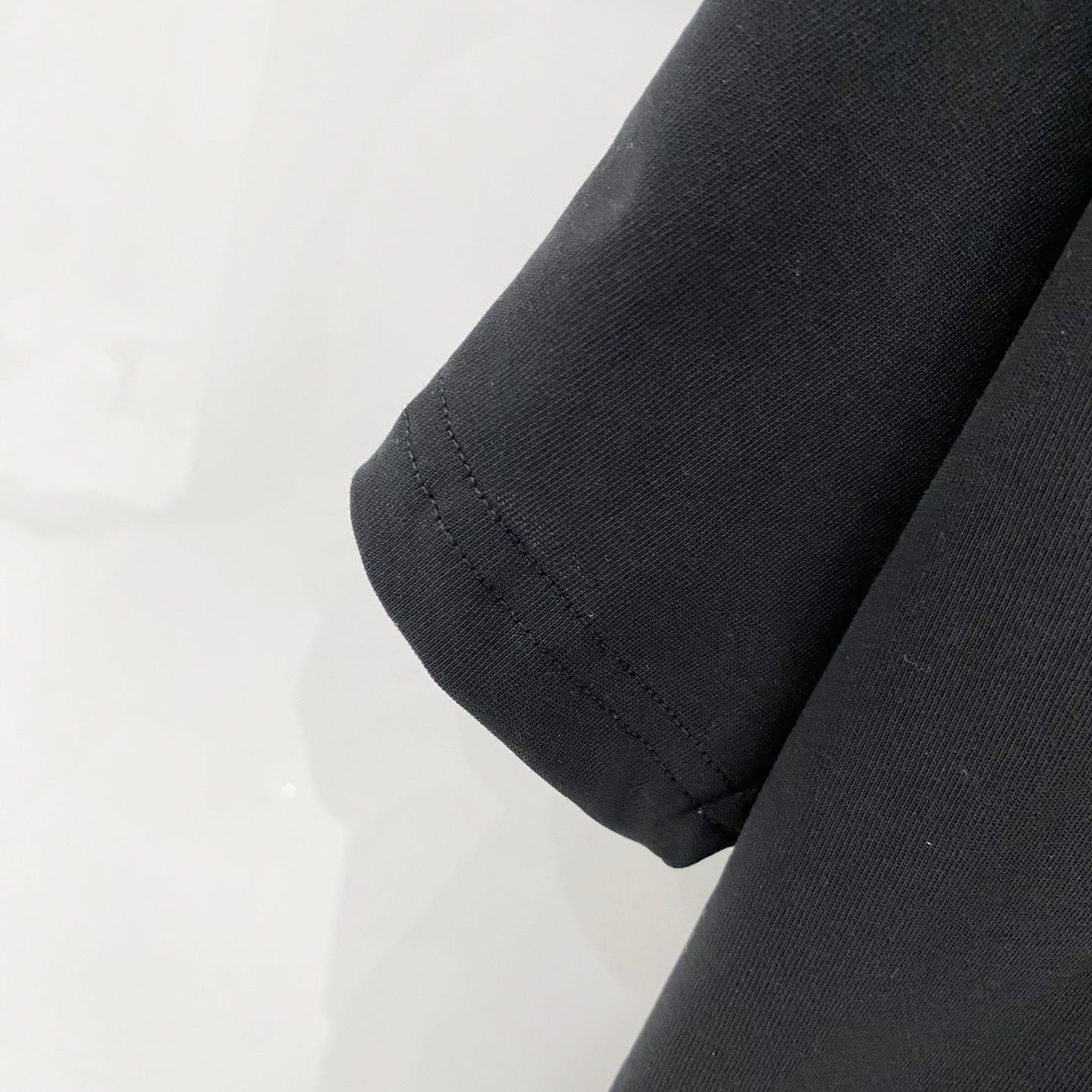 Black T-shirt sleeve hem with stitched cuff detail