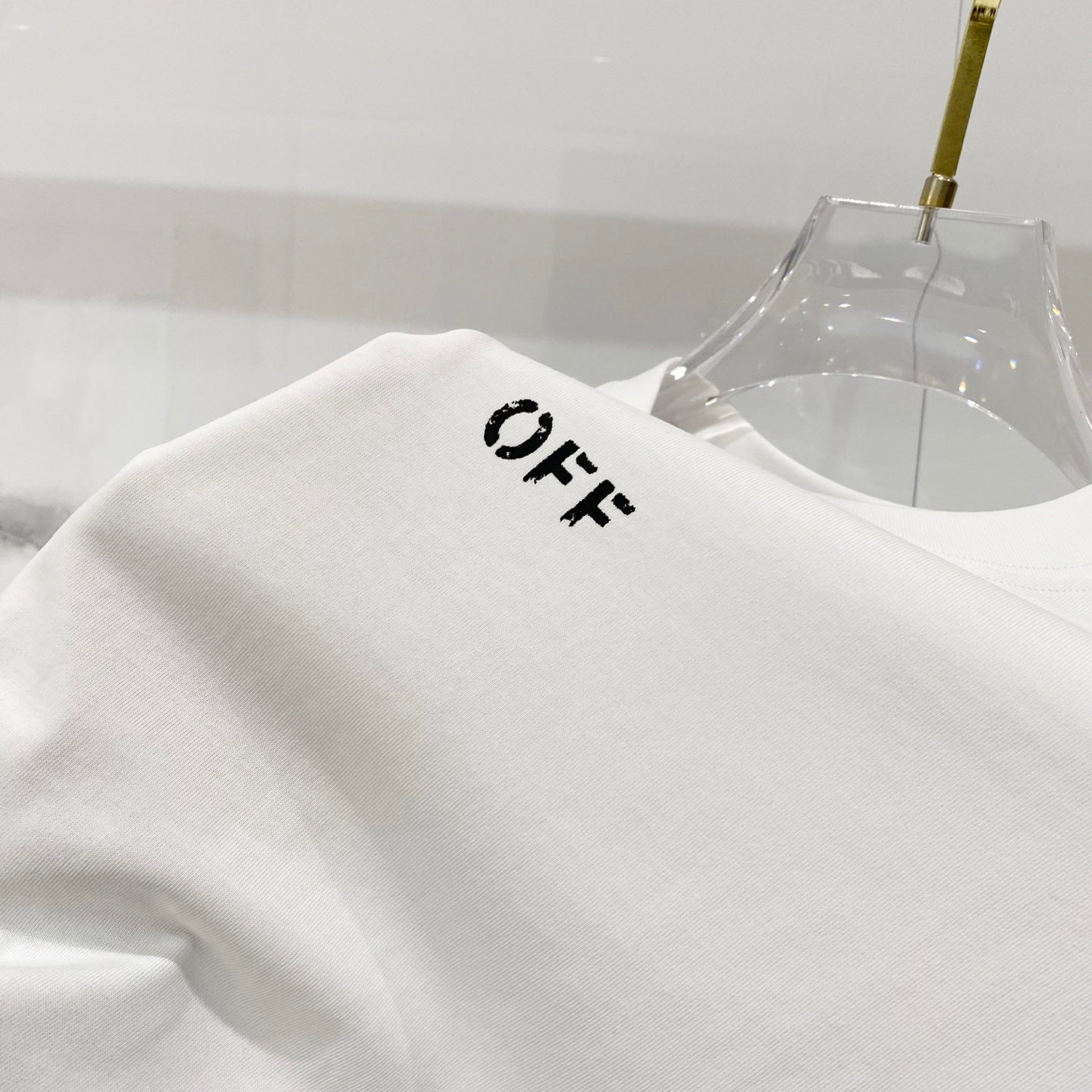 Off-white T-shirt shoulder seam with small OFF logo