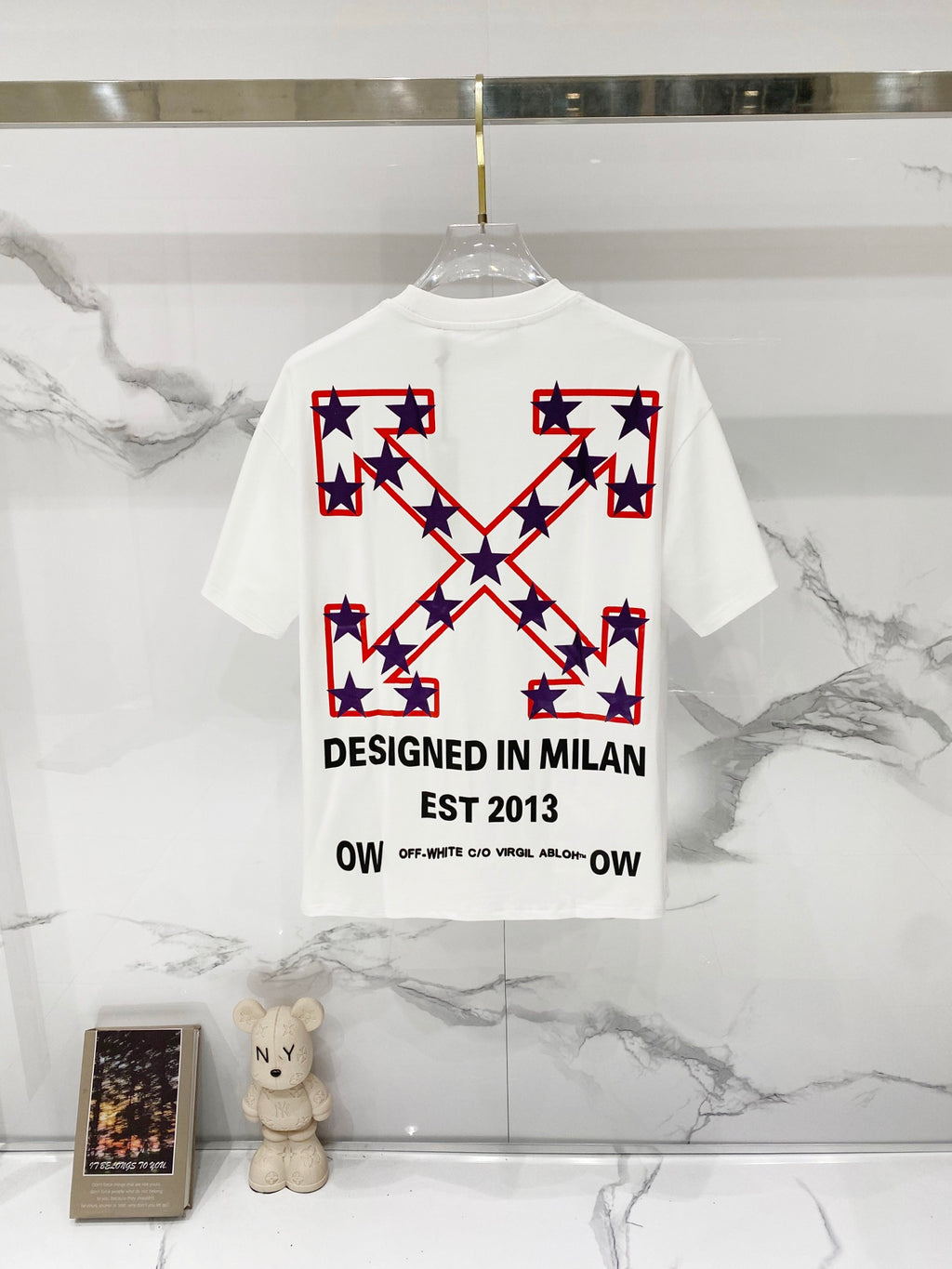 White short-sleeve T-shirt with large star cross graphic and 'DESIGNED IN MILAN'