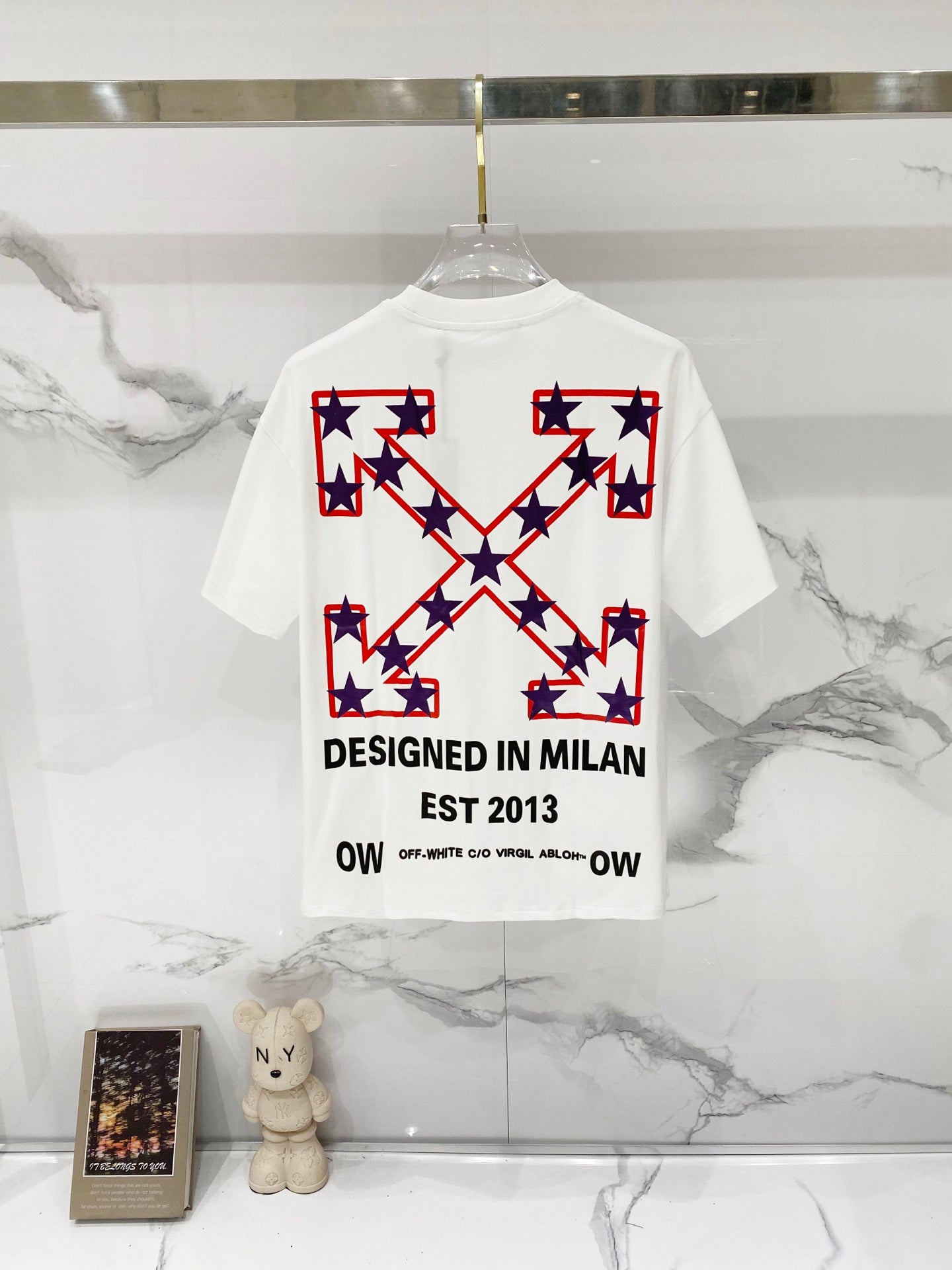 White short-sleeve T-shirt with large star cross graphic and 'DESIGNED IN MILAN'