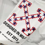White short-sleeve T-shirt with large star cross print and 'DESIGNED IN MILAN EST 2013'