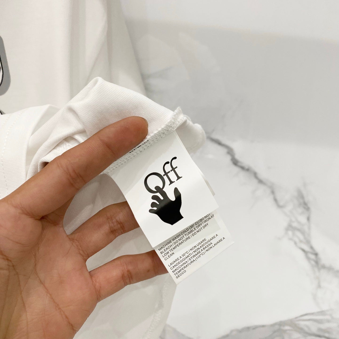 Off-white T-shirt fabric tag near collar opening