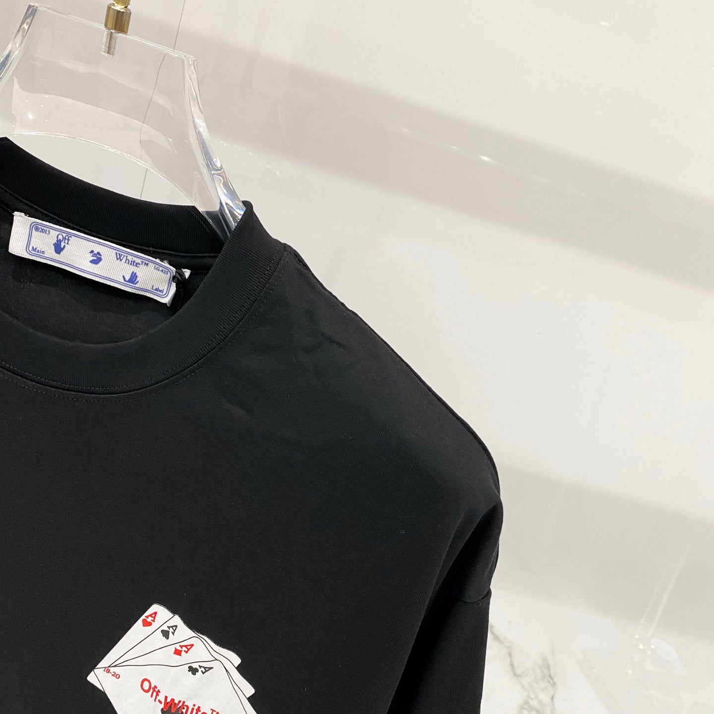 Off-White T-shirt front corner with collar tag and small card icon