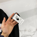 Off-White clothing tag held near dark T-shirt fabric