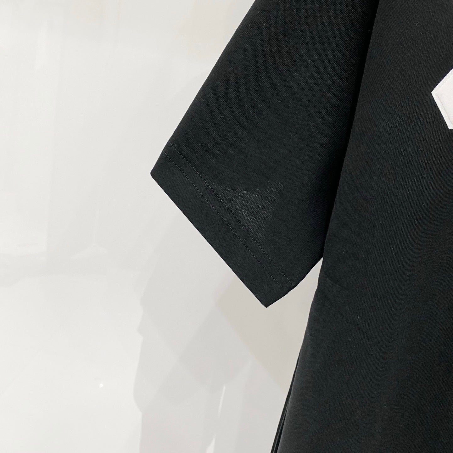 Off-White T-shirt sleeve and side seam detail on dark fabric
