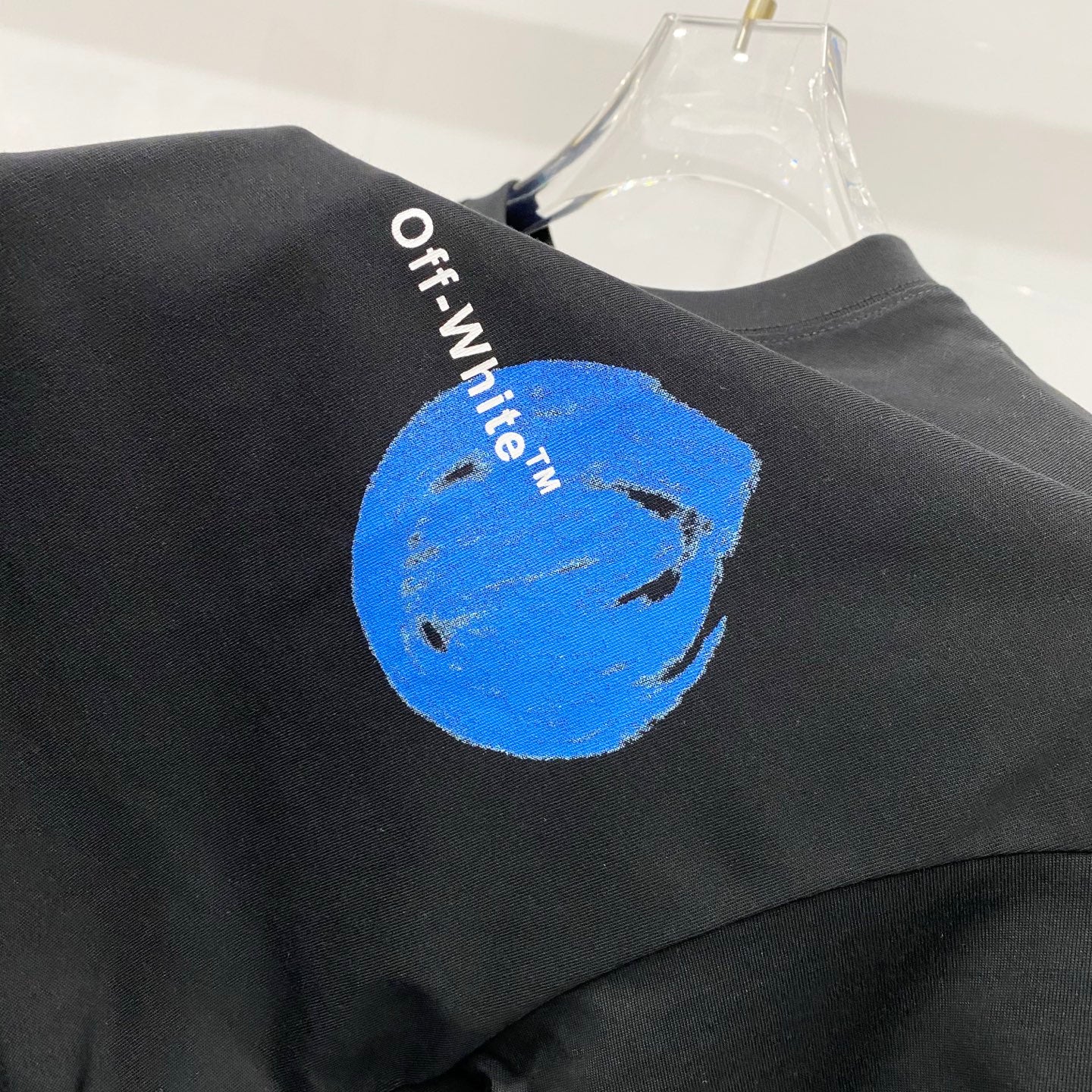 Off-White black T-shirt with blue circular graphic on the shoulder