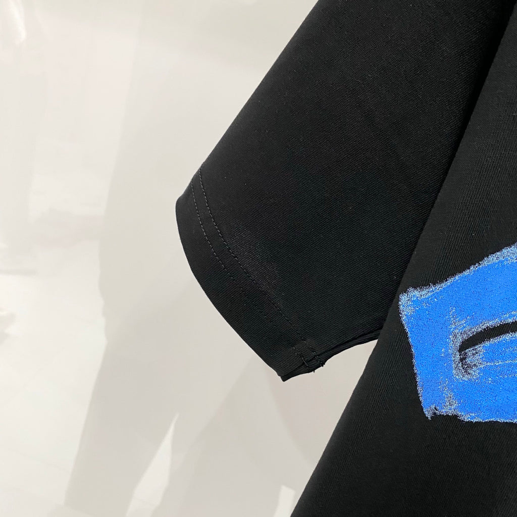 Off-White black T-shirt sleeve with partial blue brush graphic on the hem