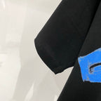 Off-White black T-shirt sleeve with partial blue brush graphic on the hem
